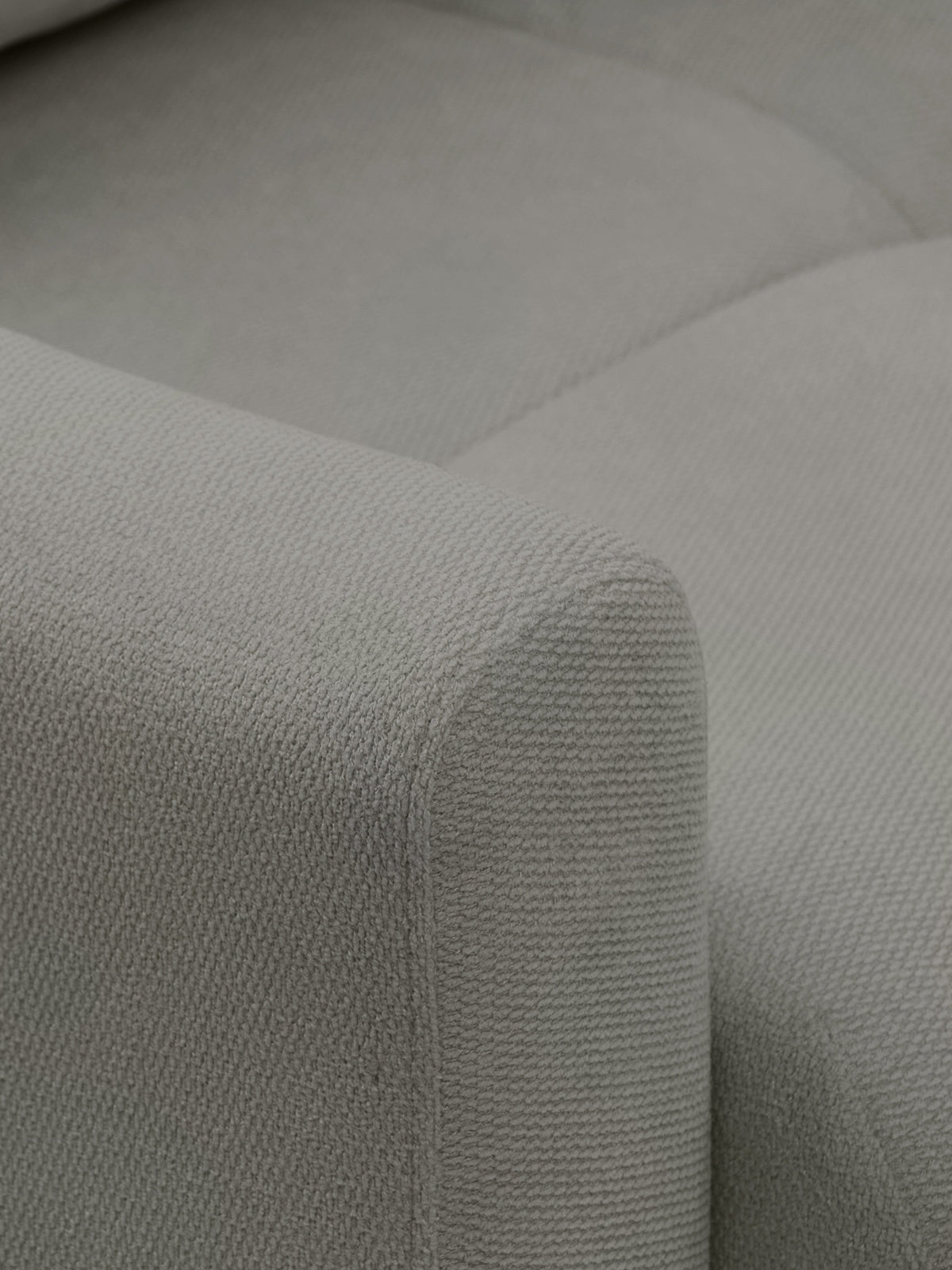 Detail podrúčky a rohu sedačky Velaro sivá látka Vela 86