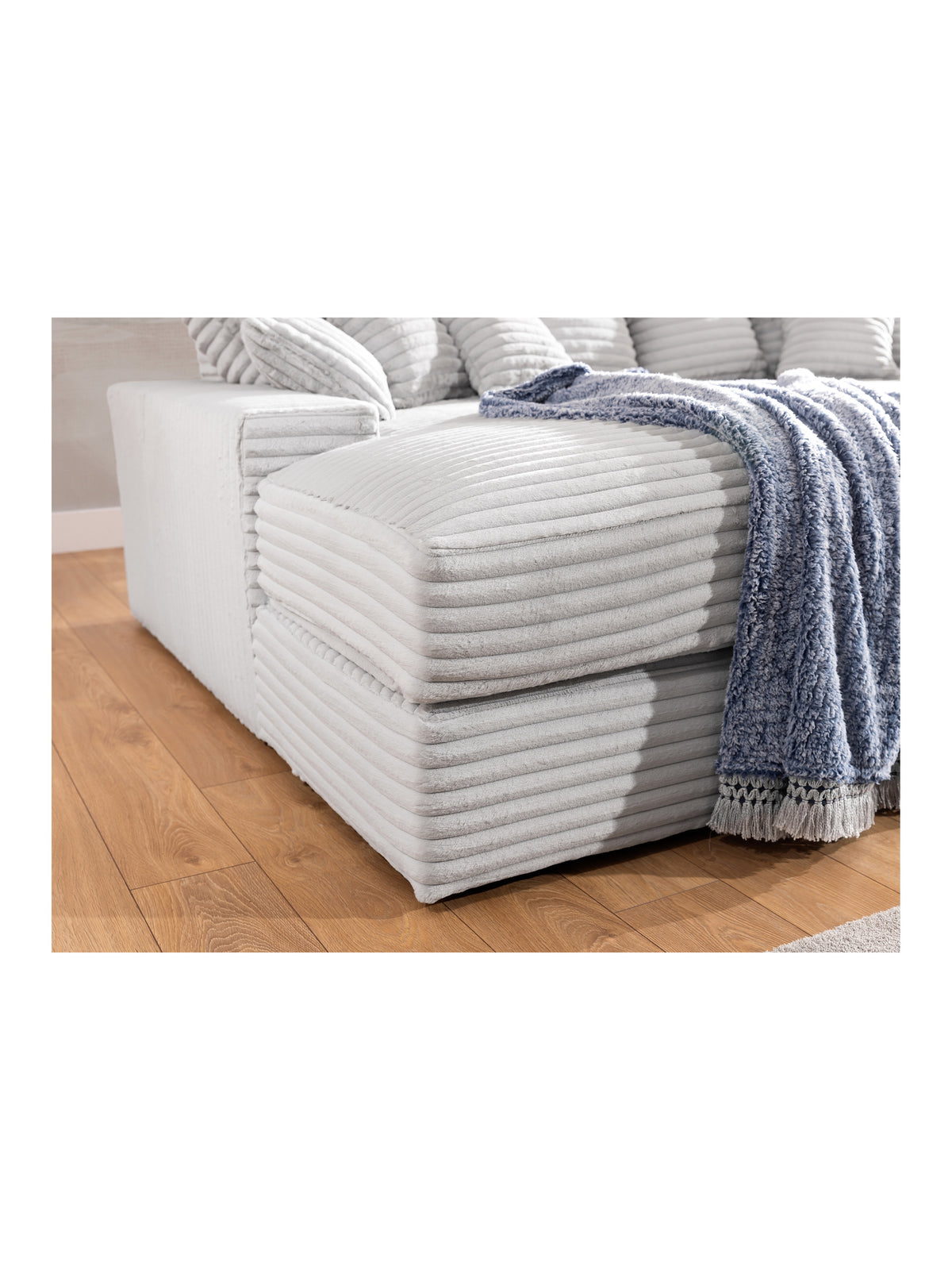 Sofa do salonu Warmi w szarym pluszu Tilia 83 z widocznym detalem bocznego zagłówka